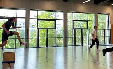 Sport verbindet Junger Erwachsener springt in Turnhalle über einen Kasten
